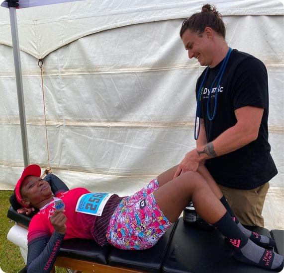 A chiropractitioner at a volunteer event helping a female athlete